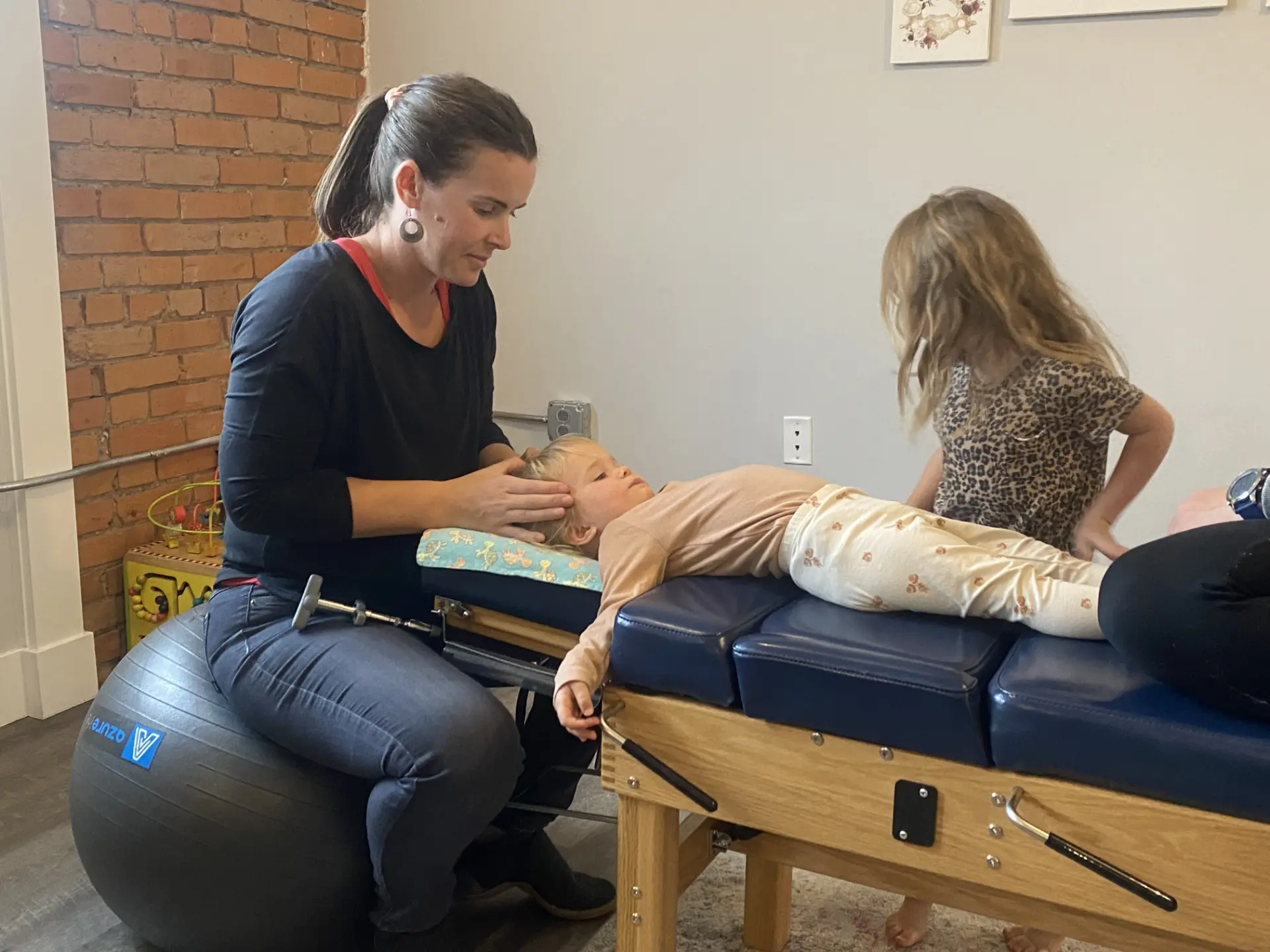 Dr. Liz performing a gentle pediatric adjustment with a child at Primal Practice in Missoula
