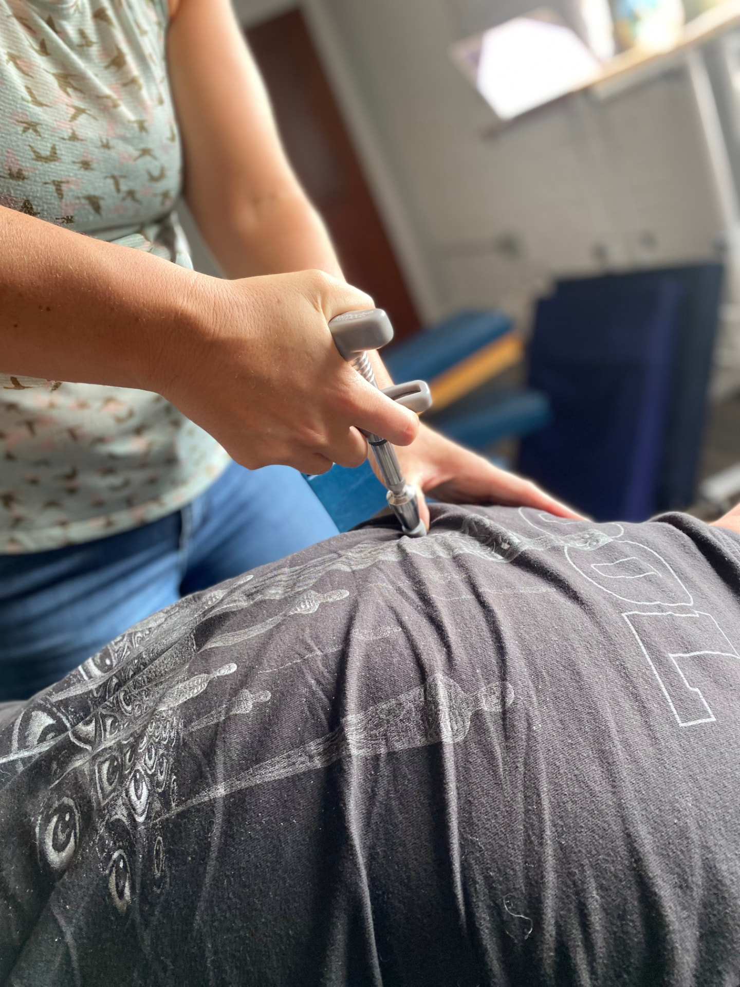 Chiropractor uses a gentle adjusting tool on a patient at Primal Practice in Missoula